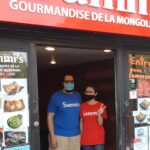 Sammi Liang and Tony Melki wave from the window of their new NDG restaurant.