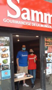 Sammi Liang and Tony Melki wave from the window of their new NDG restaurant.